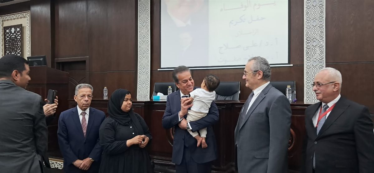 وزير الصحة يحمل ابن الشهيد الطبيب