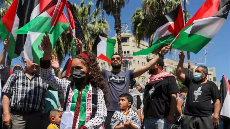 فلسطنيون يرفعون علم