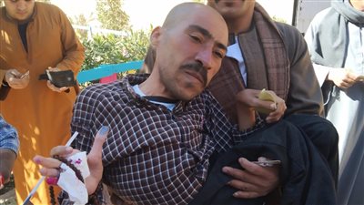محمولا على الأيدي، مواطن من ذوى الاحتياجات يدلي بصوته الانتخابي فى لجنة بأسيوط 