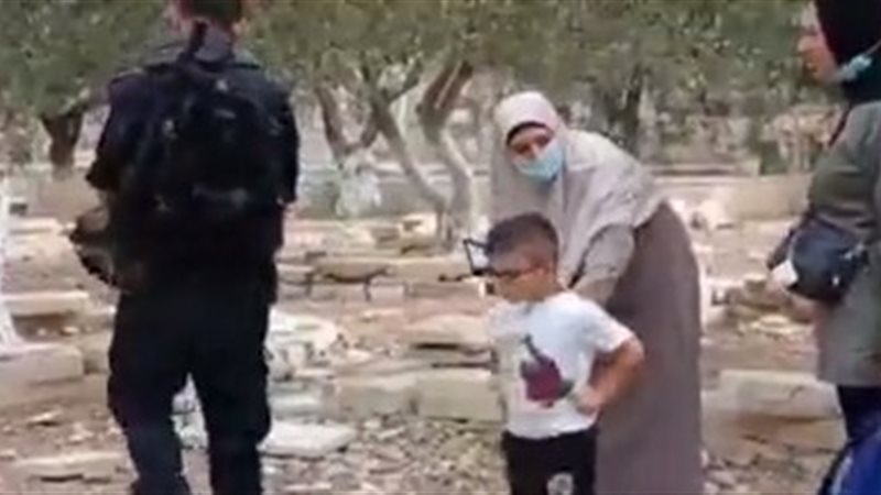 طفل يحمي سيدة فلسطينية