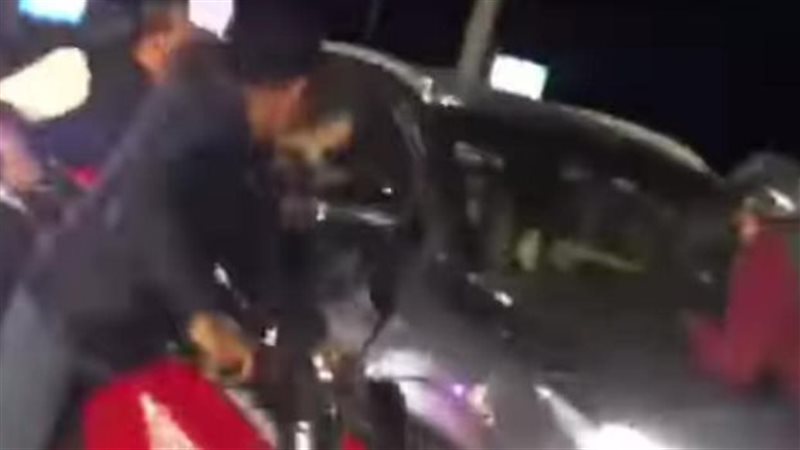  تشبث شخص بكبوت سيارة