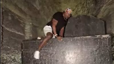 مصور أمريكي يثير غضب المصريين، صعد على تابوت بالسرابيوم وعبث بالحجر الأثري (فيديو)